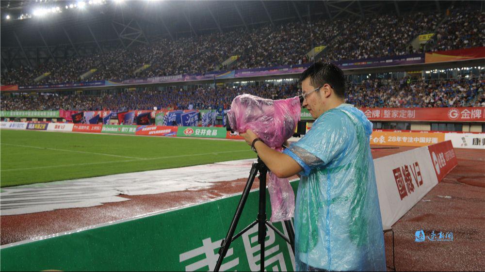 九游体育下载-主场内外看“苏超”·热力直击丨雨中“护枪人”：幕后记者用雨衣裹住设备坚持“战斗”